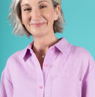 Woman wears a lilac linen shirt showing the collar